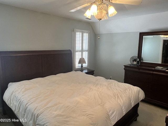 bedroom with ceiling fan, carpet floors, and vaulted ceiling