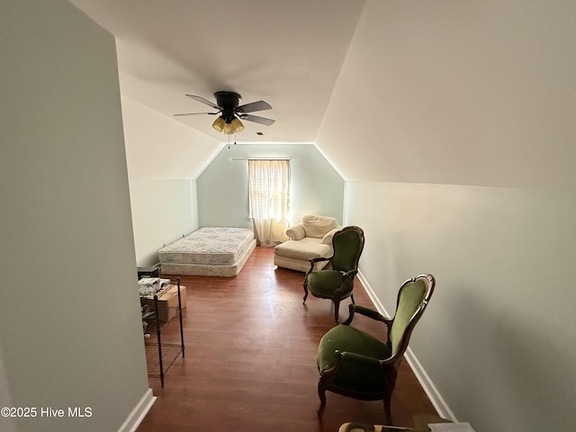 interior space with ceiling fan, baseboards, lofted ceiling, and wood finished floors