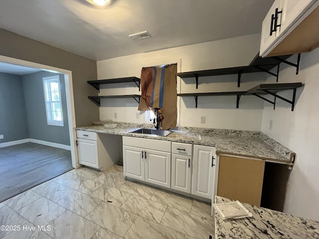 kitchen with visible vents, baseboards, white cabinetry, marble finish floor, and open shelves