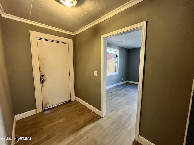 entrance foyer featuring ornamental molding, wood finished floors, and baseboards