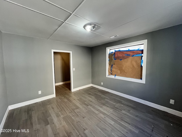 empty room with baseboards and dark wood-type flooring