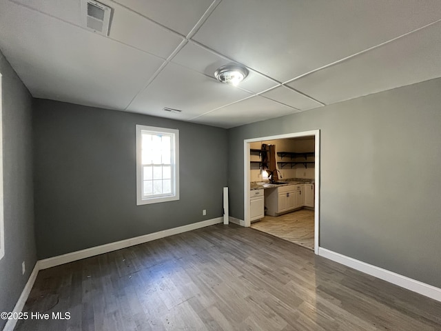 spare room with light wood-style floors, baseboards, and visible vents