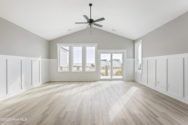 unfurnished living room with vaulted ceiling, ceiling fan, and light wood-type flooring