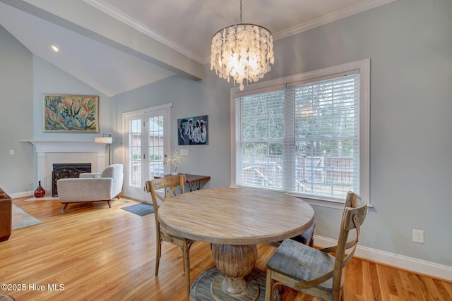 dining room with lofted ceiling, light hardwood / wood-style flooring, and an inviting chandelier