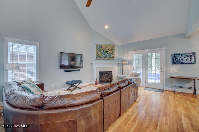 living room with light hardwood / wood-style floors and high vaulted ceiling