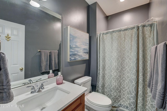 bathroom featuring curtained shower, vanity, and toilet