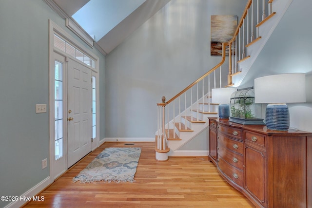 entrance foyer featuring light hardwood / wood-style flooring and lofted ceiling