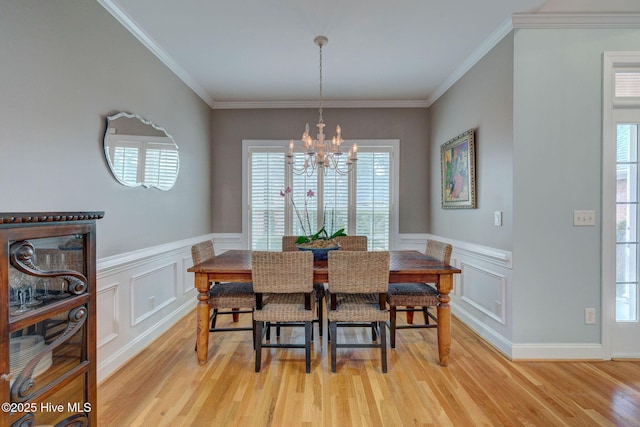 dining room featuring light hardwood / wood-style flooring, crown molding, and a notable chandelier