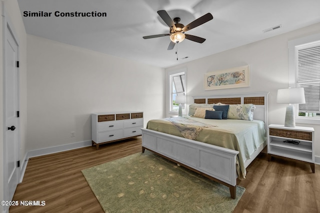 bedroom with ceiling fan and dark wood-type flooring