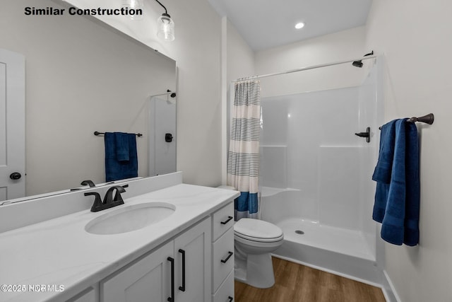 bathroom with curtained shower, hardwood / wood-style floors, vanity, and toilet