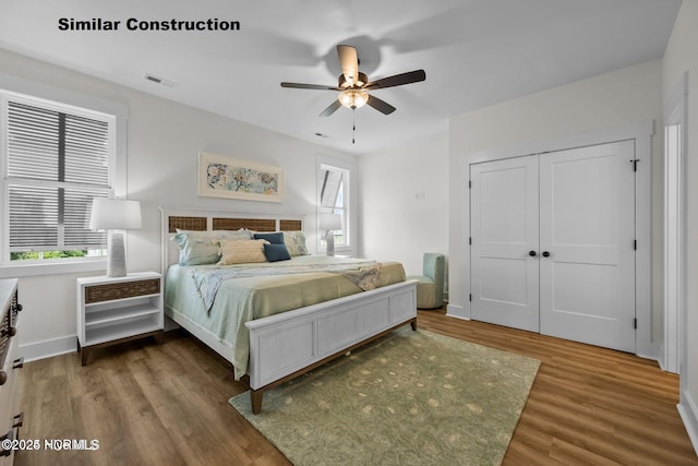 bedroom with hardwood / wood-style floors, ceiling fan, and a closet