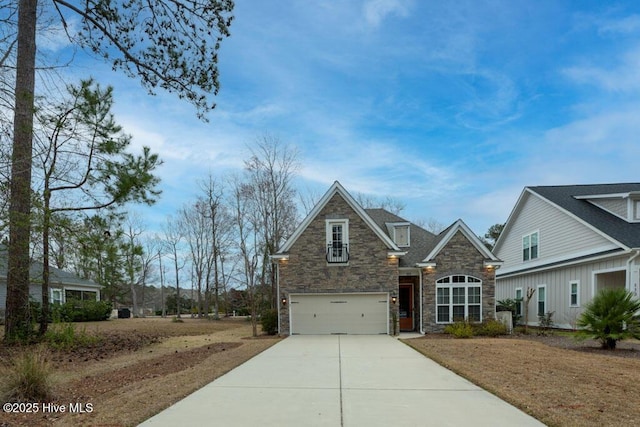 view of front facade featuring stone siding, driveway, and an attached garage