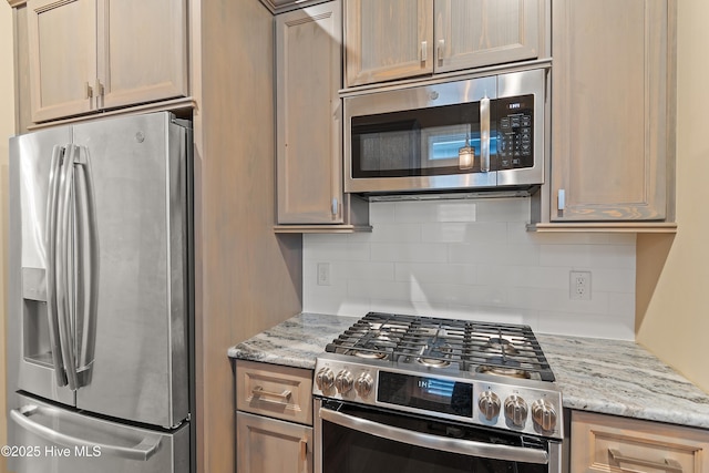 kitchen with decorative backsplash, appliances with stainless steel finishes, light brown cabinets, and light stone counters