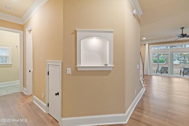 hall with light hardwood / wood-style floors and ornamental molding