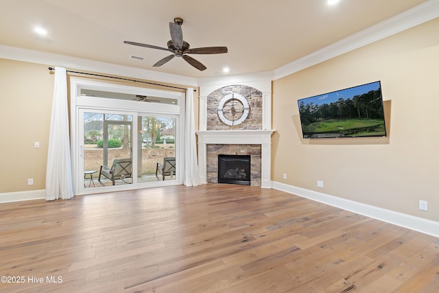 unfurnished living room featuring a tile fireplace, light wood-type flooring, ceiling fan, and crown molding