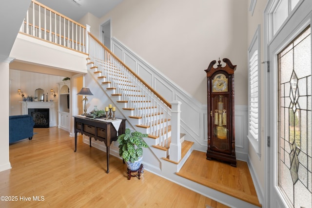 foyer featuring hardwood / wood-style floors, a towering ceiling, and a healthy amount of sunlight