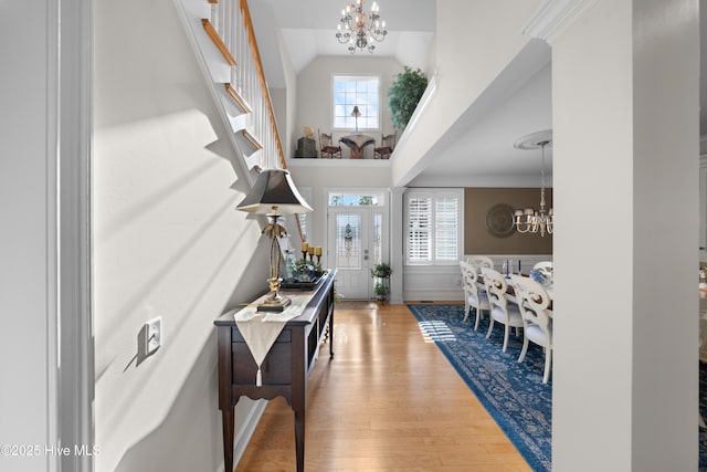 foyer entrance featuring a chandelier, hardwood / wood-style flooring, and crown molding