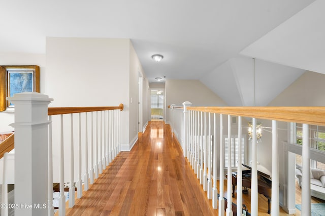 hallway with light hardwood / wood-style floors and lofted ceiling