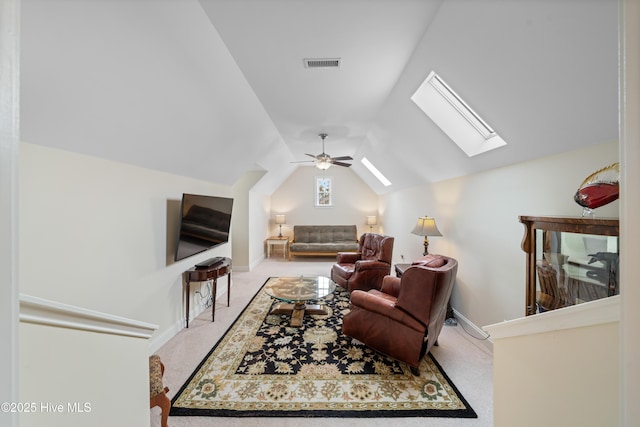 carpeted living room with lofted ceiling with skylight and ceiling fan