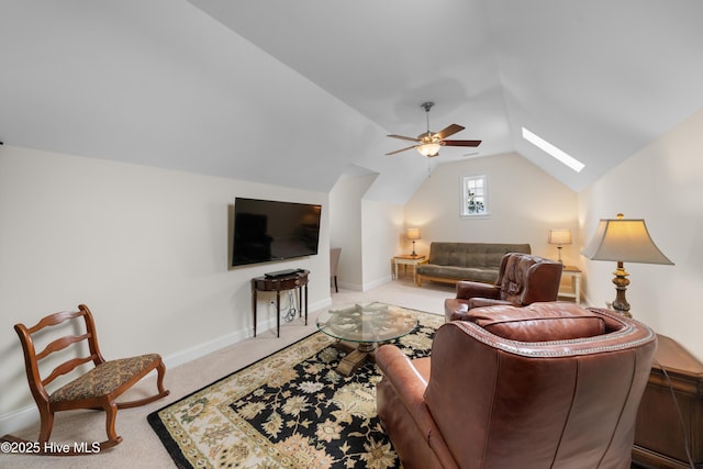 living room featuring ceiling fan, light colored carpet, and lofted ceiling with skylight