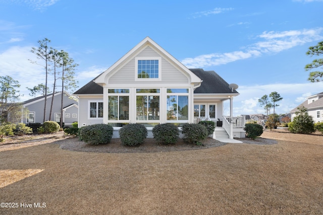 back of property with a yard and covered porch
