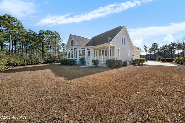 view of home's exterior featuring concrete driveway, a porch, and a garage