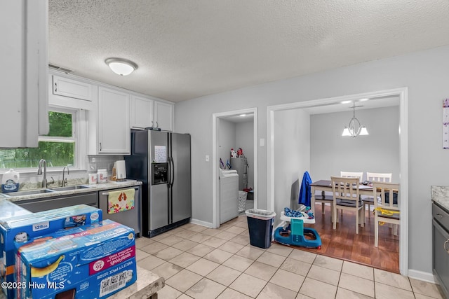 kitchen with a notable chandelier, white cabinetry, stainless steel appliances, and light tile patterned floors