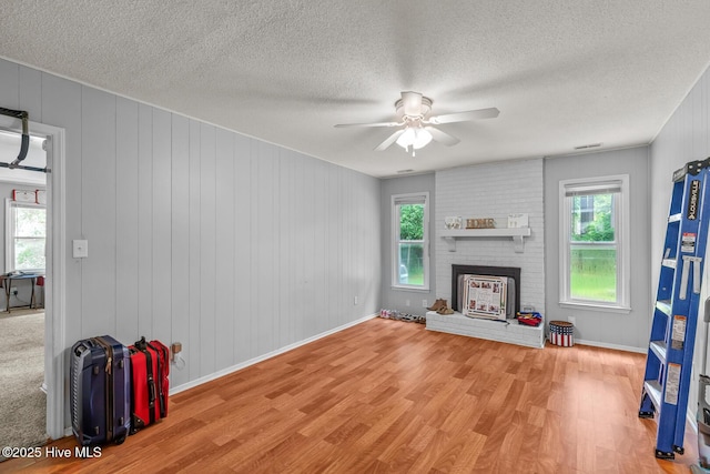 living room featuring hardwood / wood-style floors, plenty of natural light, and a brick fireplace