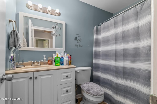 bathroom with toilet, vanity, and a shower with shower curtain