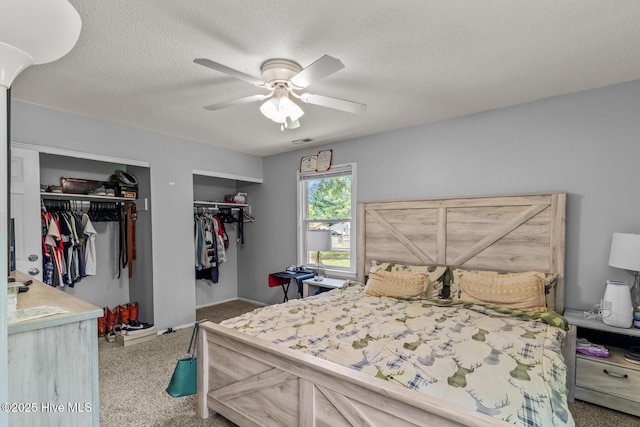 bedroom featuring multiple closets, ceiling fan, and a textured ceiling