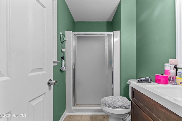 bathroom featuring tile patterned flooring, vanity, toilet, and an enclosed shower