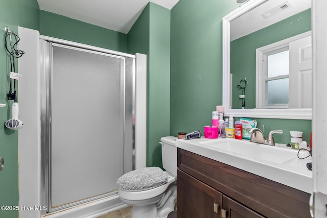 bathroom featuring tile patterned floors, vanity, toilet, and a shower with shower door