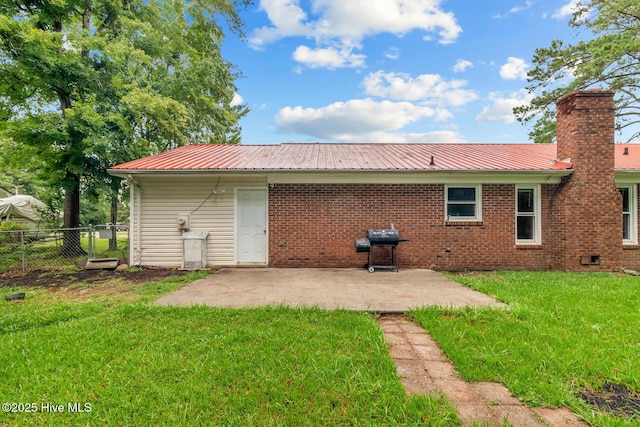 rear view of property featuring a lawn and a patio area