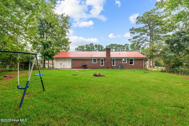 back of property with a playground and a yard