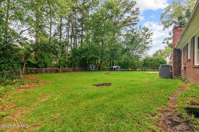 view of yard featuring cooling unit and a storage shed