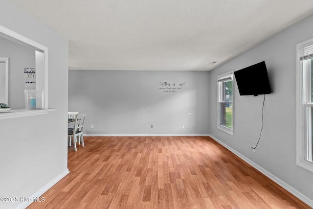 spare room with light hardwood / wood-style floors and a textured ceiling