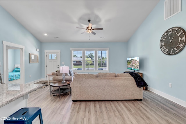 living room featuring light hardwood / wood-style flooring and ceiling fan