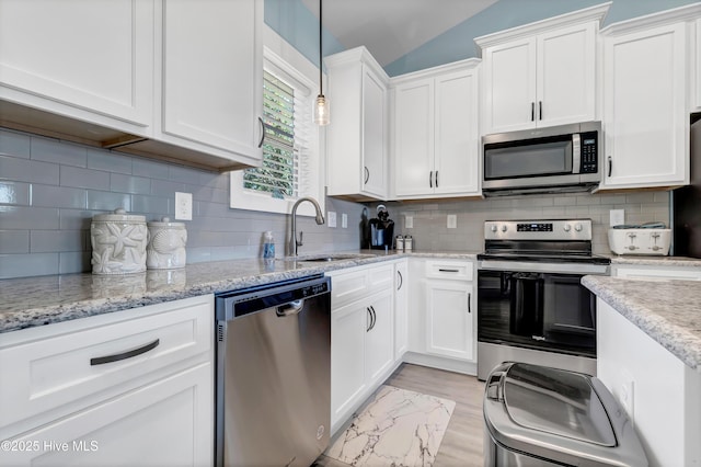 kitchen featuring pendant lighting, sink, white cabinetry, and stainless steel appliances