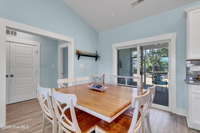 dining space featuring lofted ceiling and light wood-type flooring