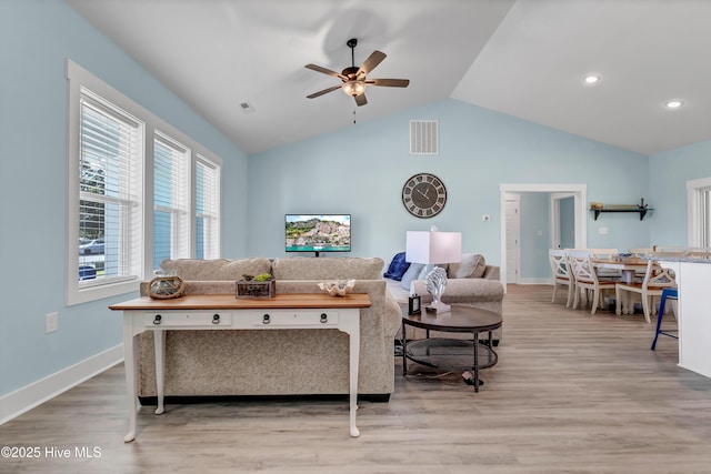 living room featuring ceiling fan, light wood-type flooring, and lofted ceiling