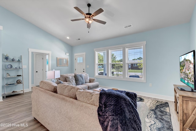 living room with ceiling fan, light hardwood / wood-style floors, and lofted ceiling