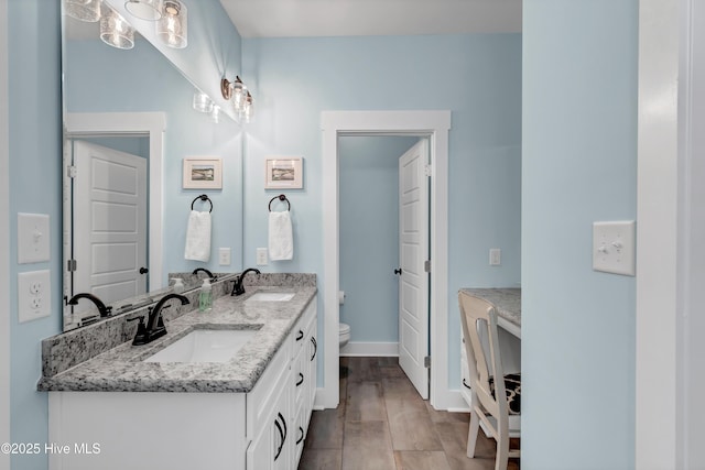 bathroom featuring vanity, wood-type flooring, and toilet