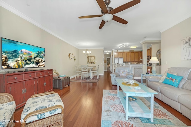 living room with ceiling fan with notable chandelier, hardwood / wood-style flooring, and crown molding