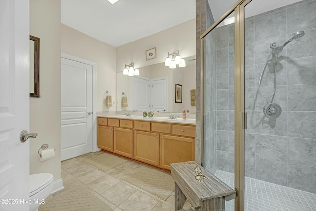 bathroom featuring tile patterned floors, vanity, toilet, and a shower with door