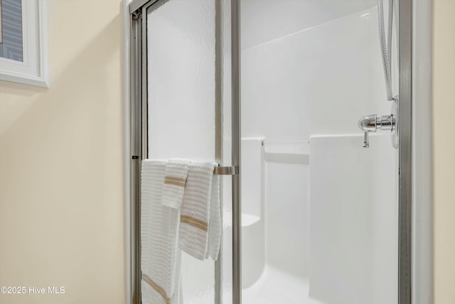 bathroom featuring a shower with shower door