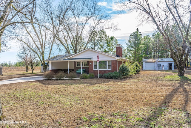 ranch-style home with a garage, an outdoor structure, and a front yard