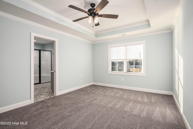 empty room featuring a raised ceiling, crown molding, carpet flooring, and ceiling fan