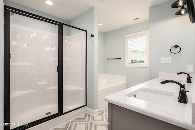 bathroom featuring vanity and independent shower and bath