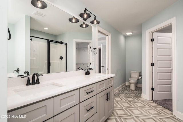 bathroom featuring vanity, toilet, and an enclosed shower