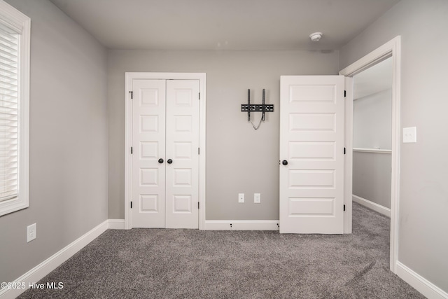 unfurnished bedroom featuring a closet and carpet flooring